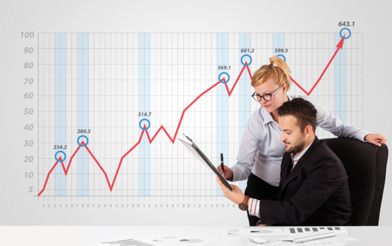 Young businessman and businesswoman calculating stock market with rising graph in the background