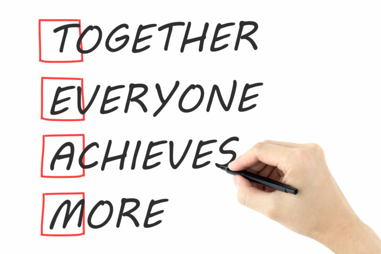 Together Everyone Achieves More written by man's hand on white background